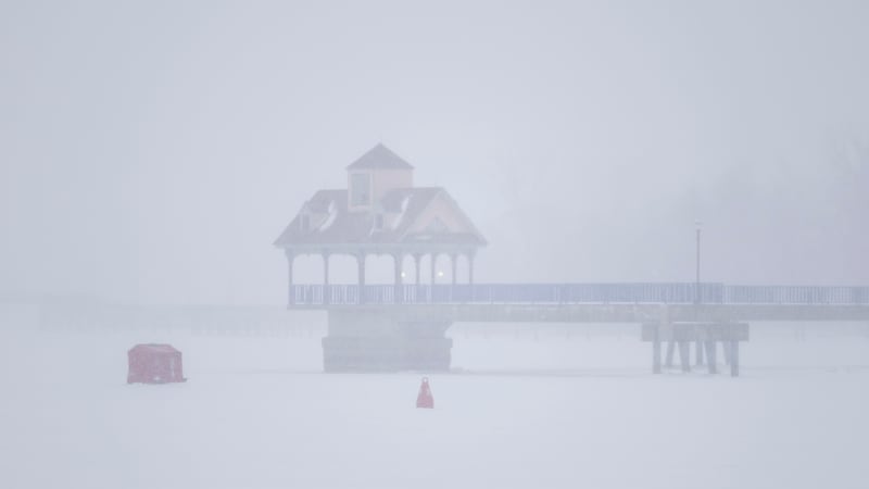 Una choza roja ha sido colocada sobre el hielo del río Saginaw mientras una tormenta de nieve...