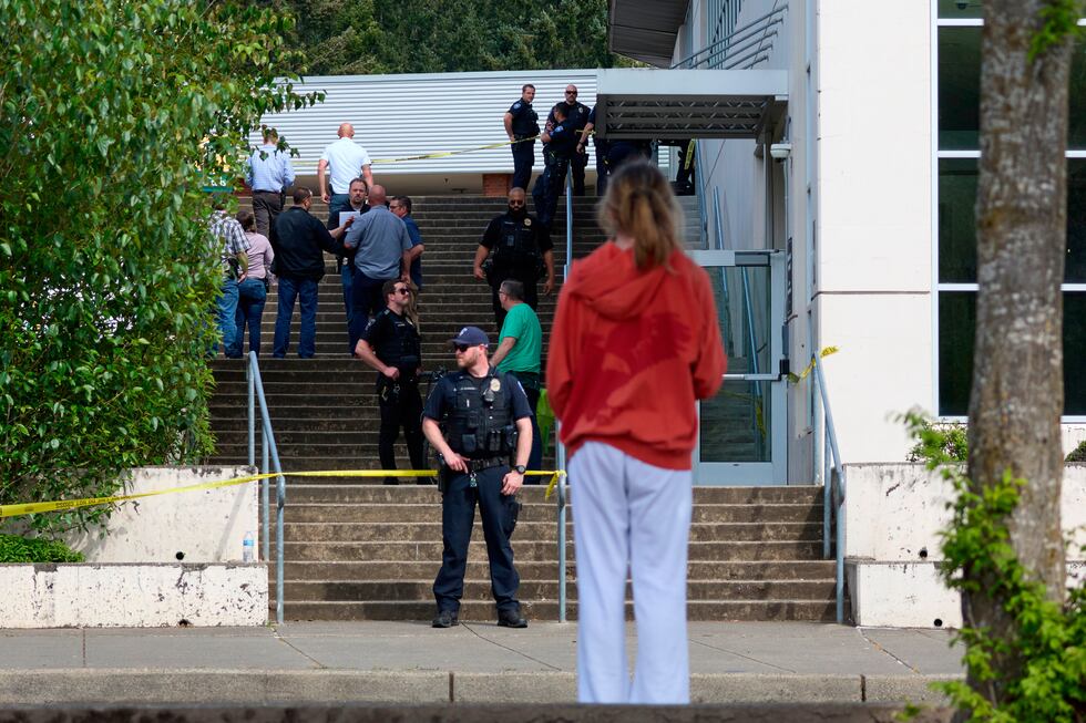 Un estudiante observa a agentes de la Policía de Tacoma luego de que varias personas...