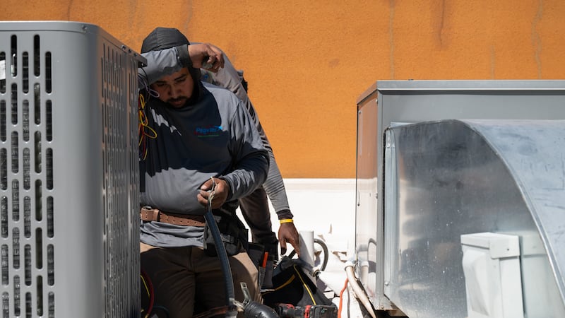 Brian Hermosillo se limpia el sudor después de instalar una nueva unidad de aire acondicionado...