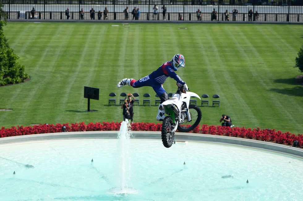 Un deportista de motor y especialista hace un salto en motocicleta antes de los combates UFC...