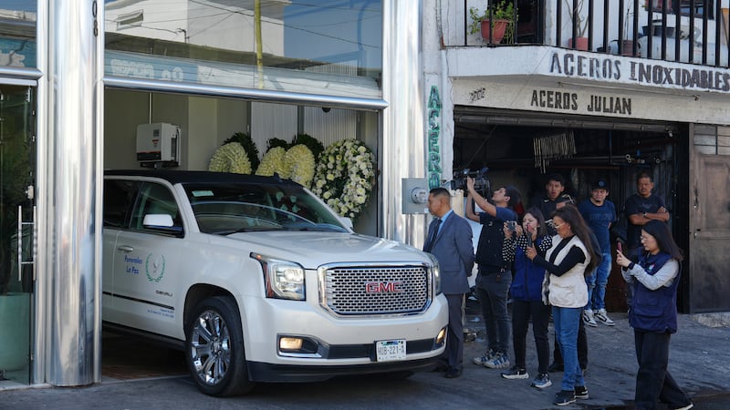 Periodistas toman fotos y videos de un vehículo que transporta los restos de Nemesio Oseguera,...